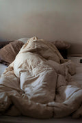 White pinch pleat style comforter on a made bed