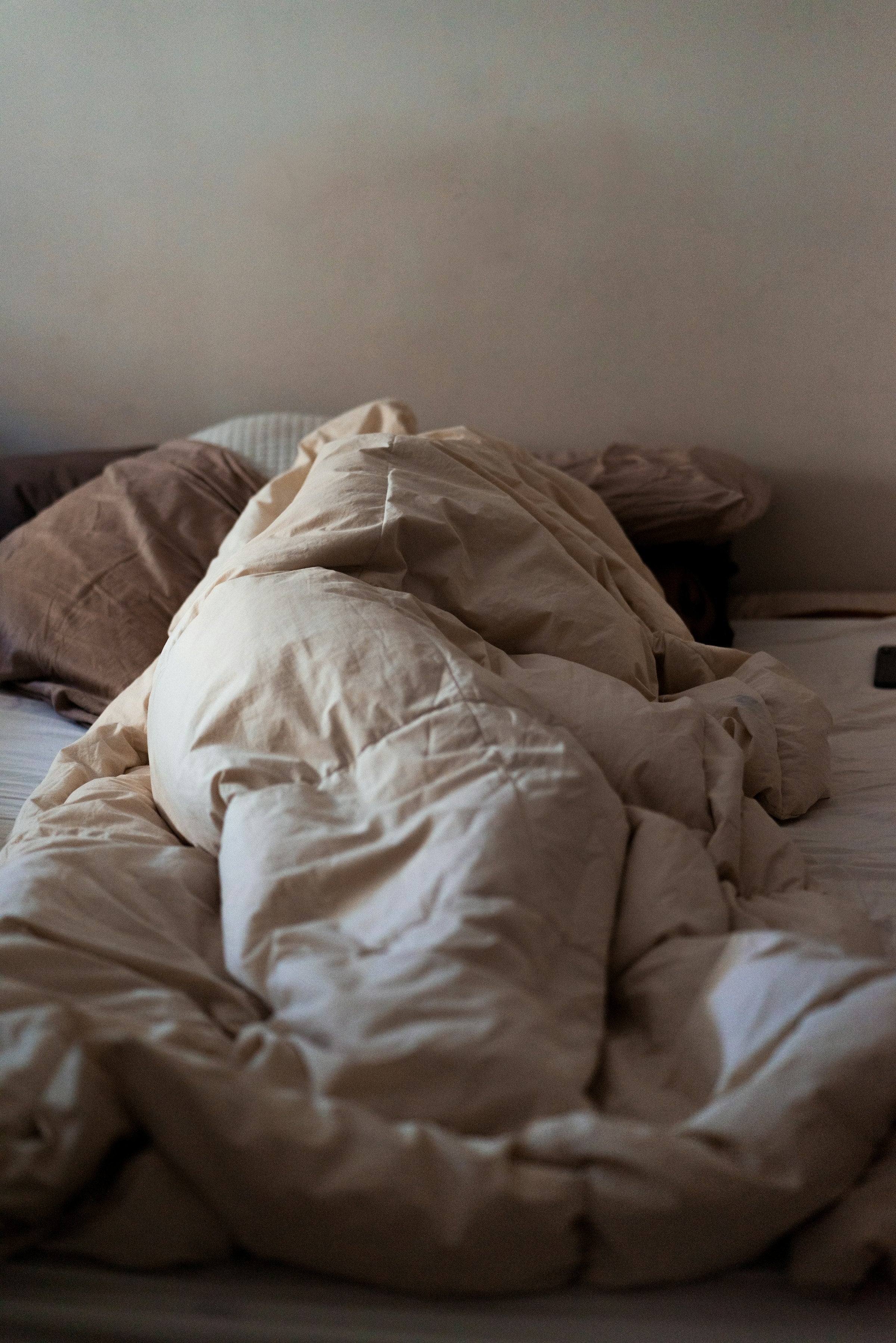 White pinch pleat style comforter on a made bed