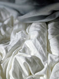 Folded cotton pillowcases in a neutral floral-textured fabric