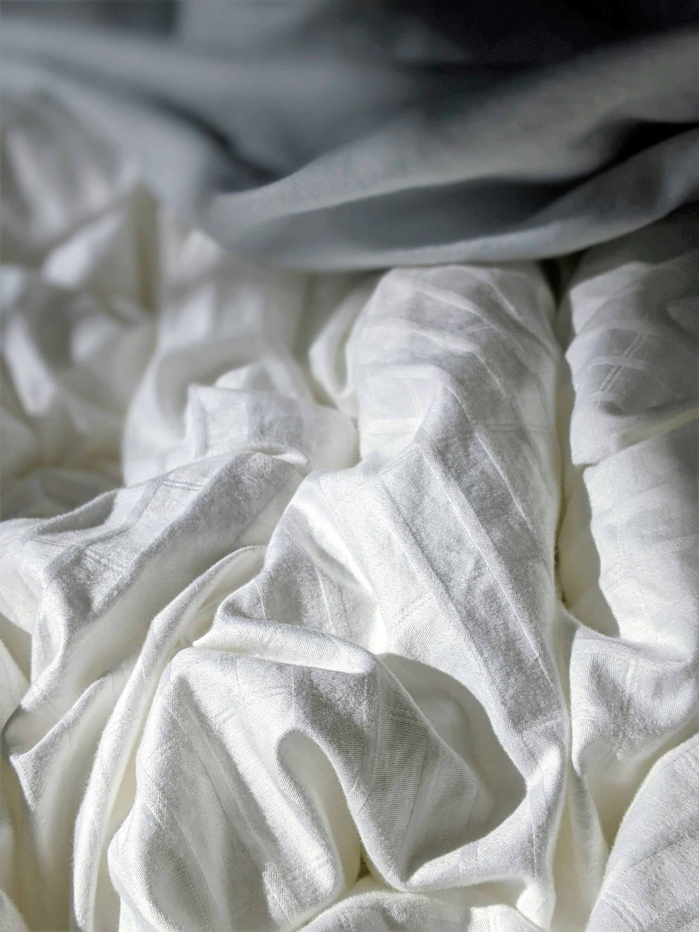 Folded cotton pillowcases in a neutral floral-textured fabric