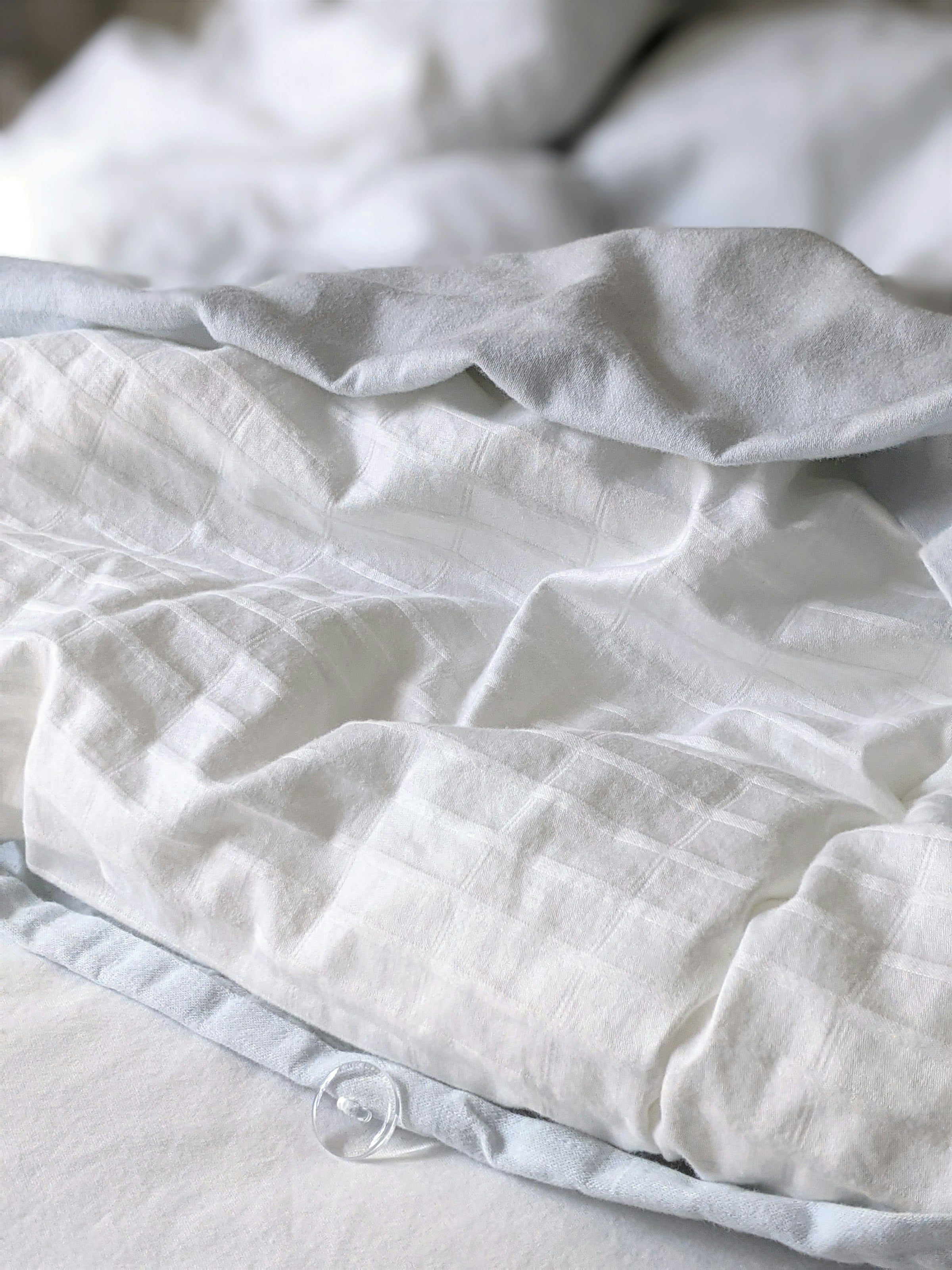 Folded bed sheet set in a neutral striped fabric