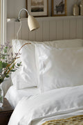 Made bed with white linens and a tailored skirt