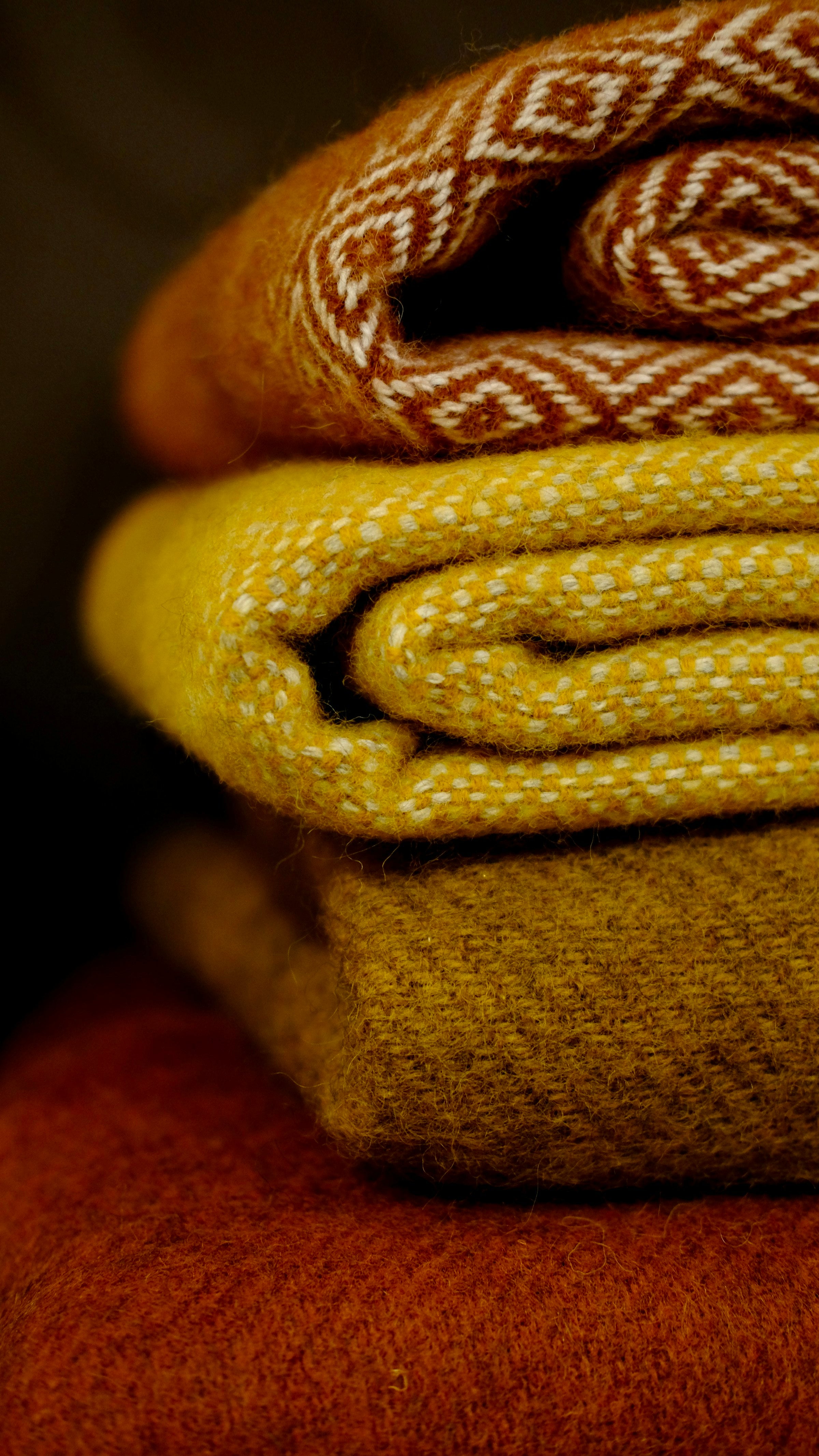 A stack of folded fleece throw blankets